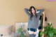 A woman standing in front of a mirror in a living room.