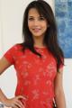 A woman in a red shirt posing for a picture.