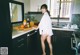 A woman standing in a kitchen next to a counter.