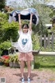 A woman holding up a white shirt over her head.