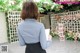 A woman in a blue shirt and black skirt holding a clipboard.